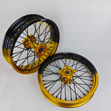 Two motorcycle wheels with black and gold rims on a white background